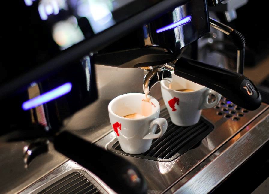 Dve šálky kávy sa nalievajú do barového espresso kávovaru Aria.